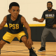 oung basketball player practicing a low dribble drill on an indoor court, guided by a coach, in Pro Skills Basketball brand colors.