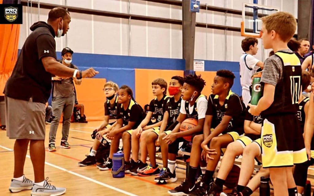 Coach teaching his youth basketball team during practice