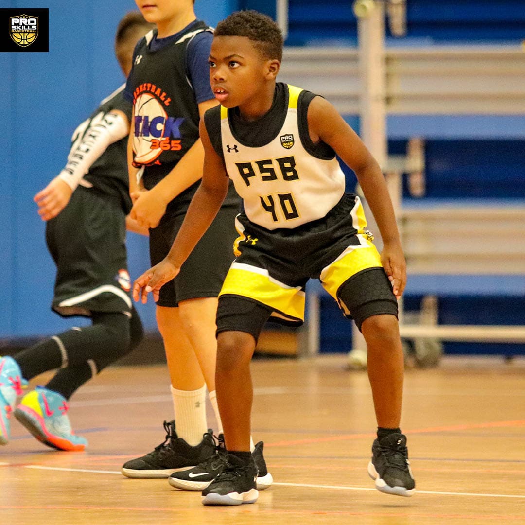Young boy playing defense in a youth basketball game