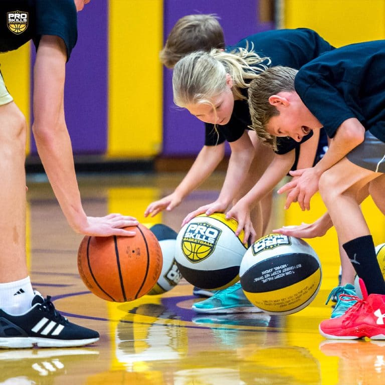 Children practice dribbling drills at a Pro Skills Basketball camp