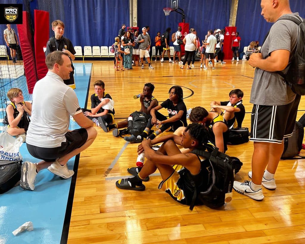 Pro Skills Basketball Coach talking to a youth basketball team on the court after a game