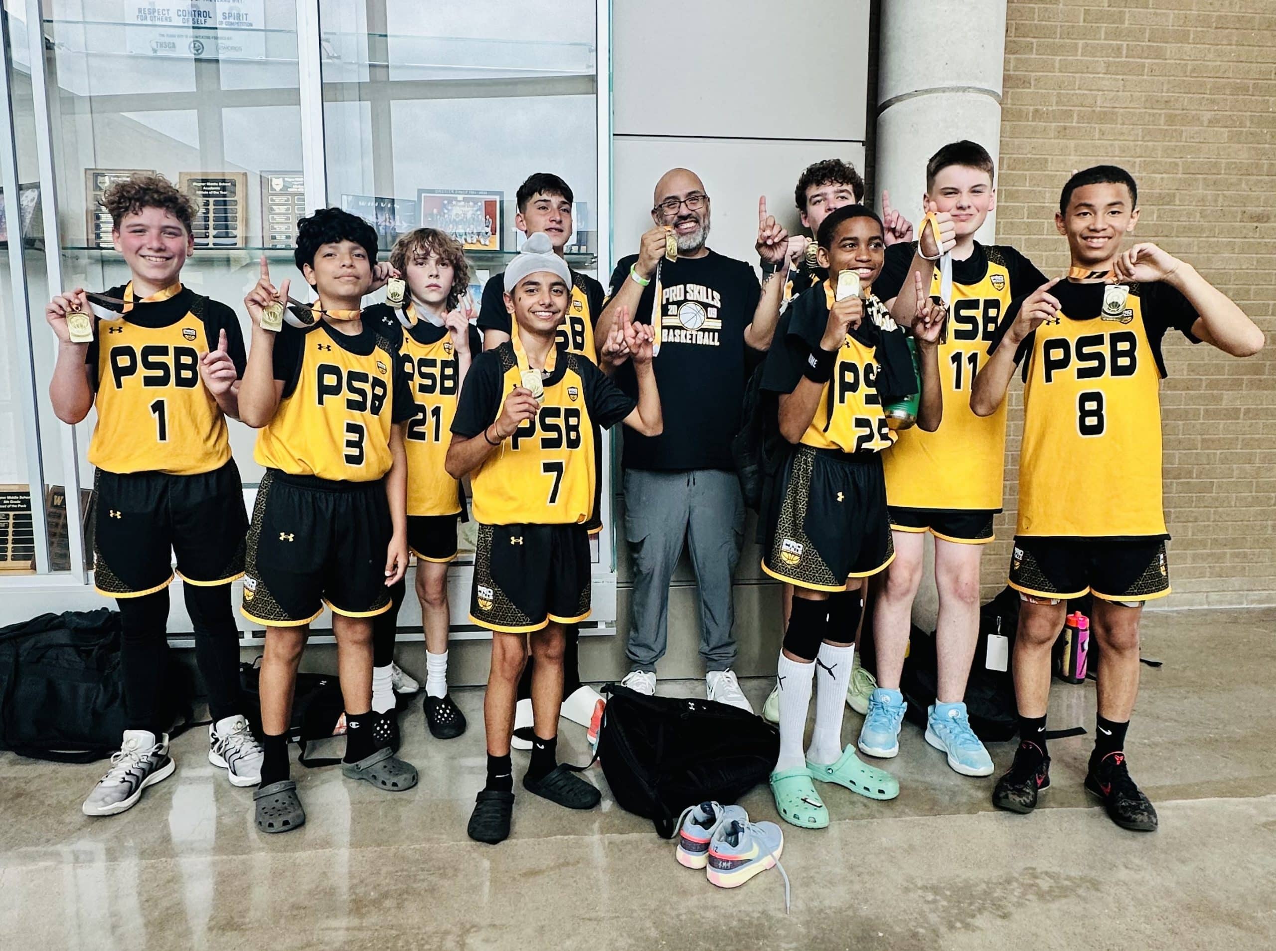 PSB boys basketball team posing with championship medals after an AAU tournament