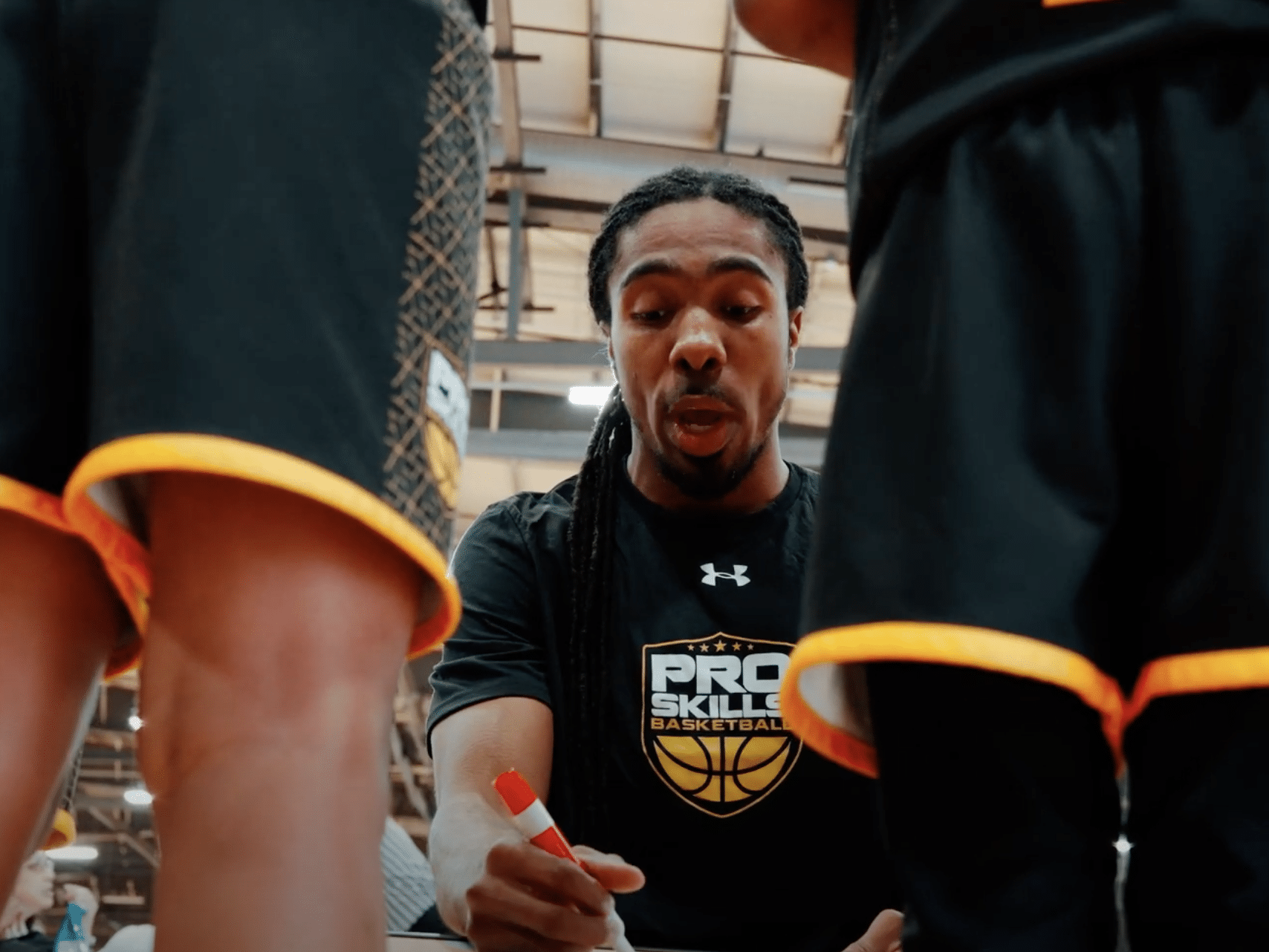 PSB coach drawing up a play with marker during youth basketball huddle