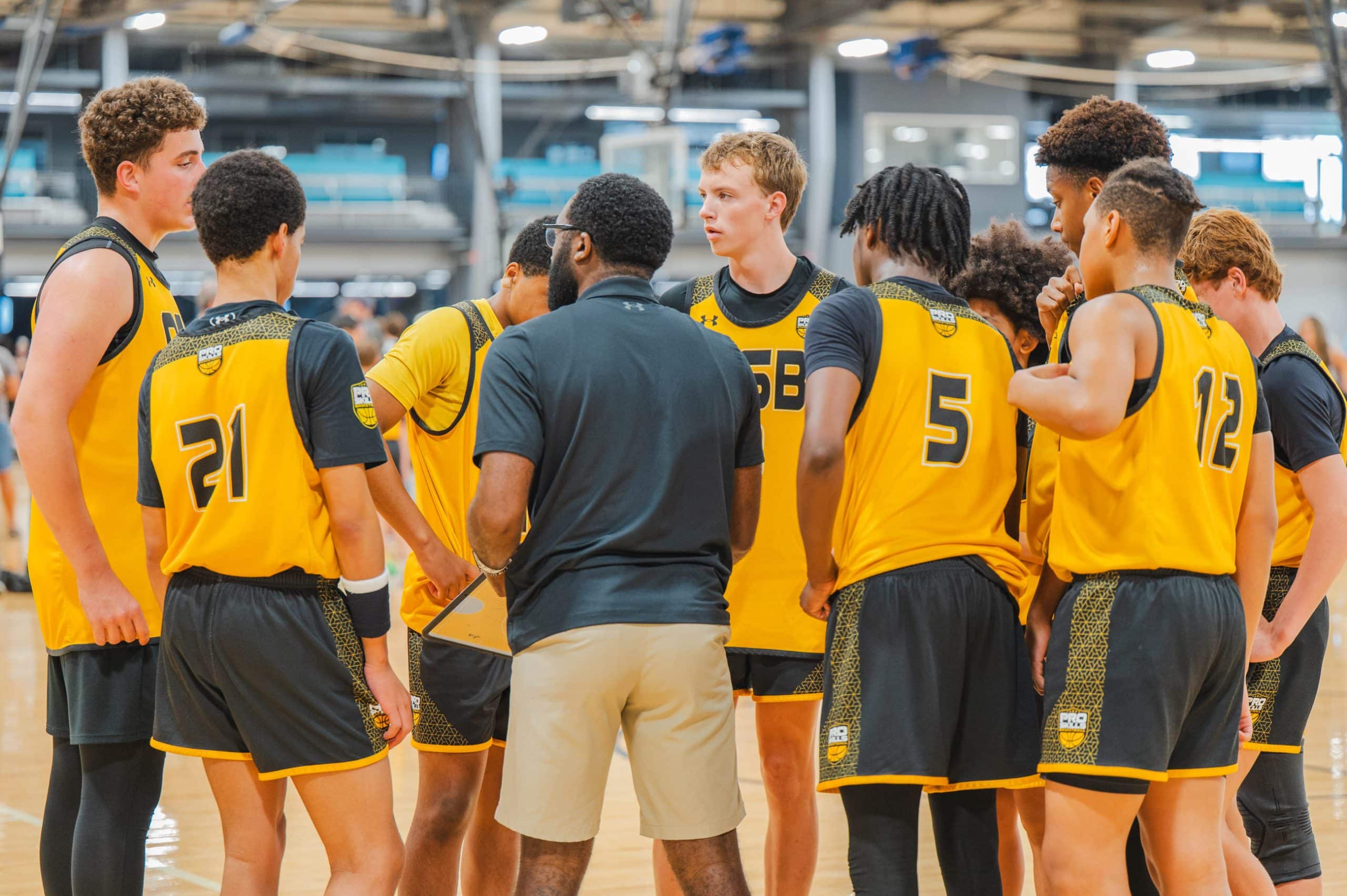 PSB coach talking to youth basketball players during AAU tournament huddle