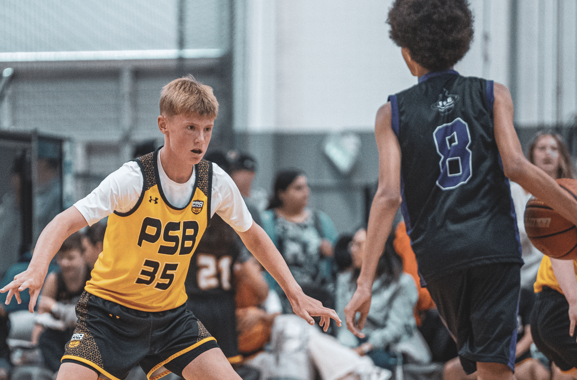 Youth basketball player in proper defensive stance, PSB player in yellow jersey at tournament