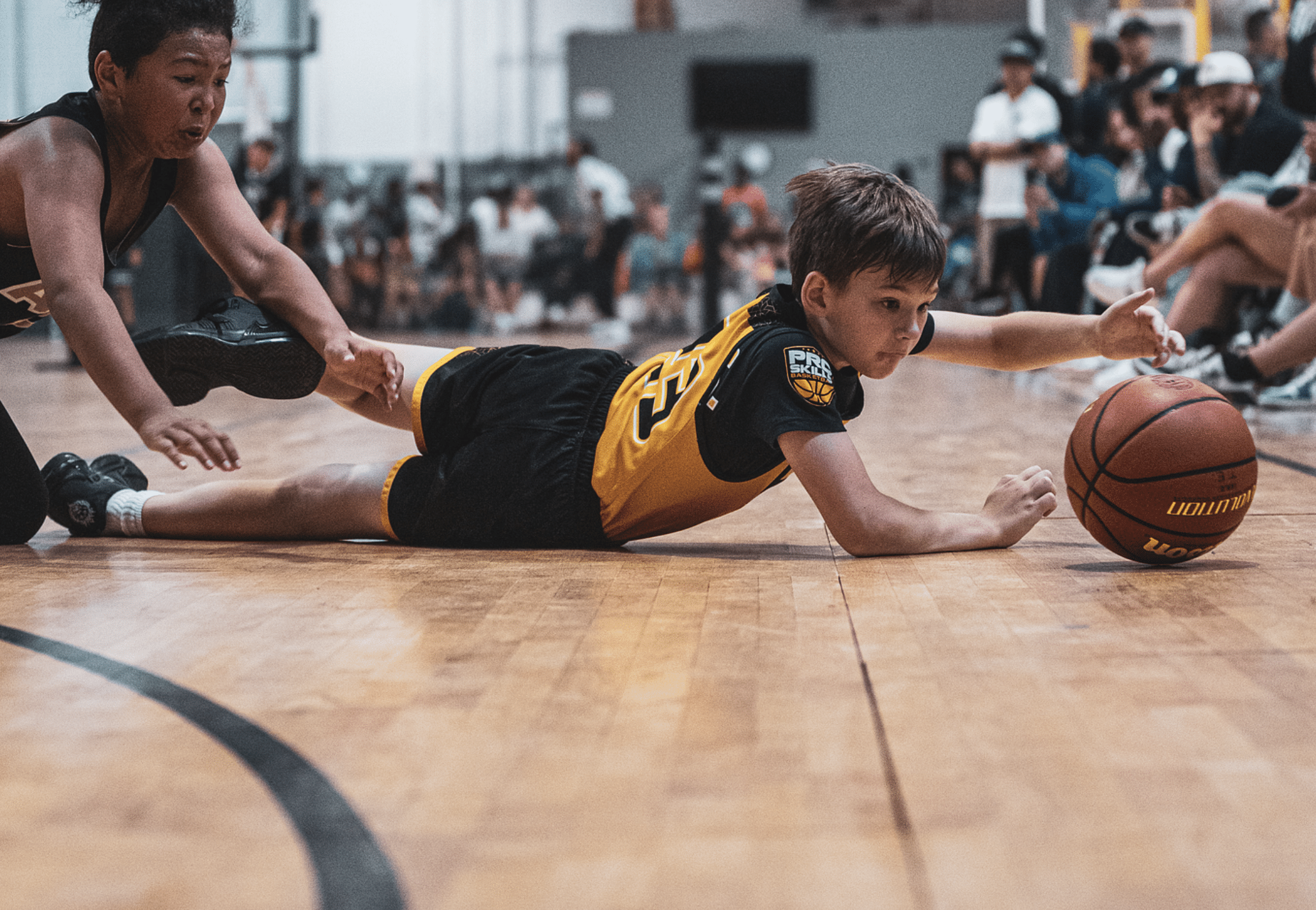 Youth basketball player diving for a loose ball during a game
