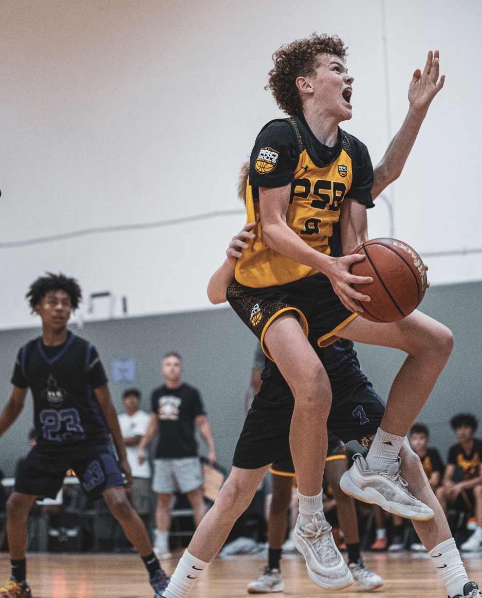 High school basketball player driving to the basket in a tournament game