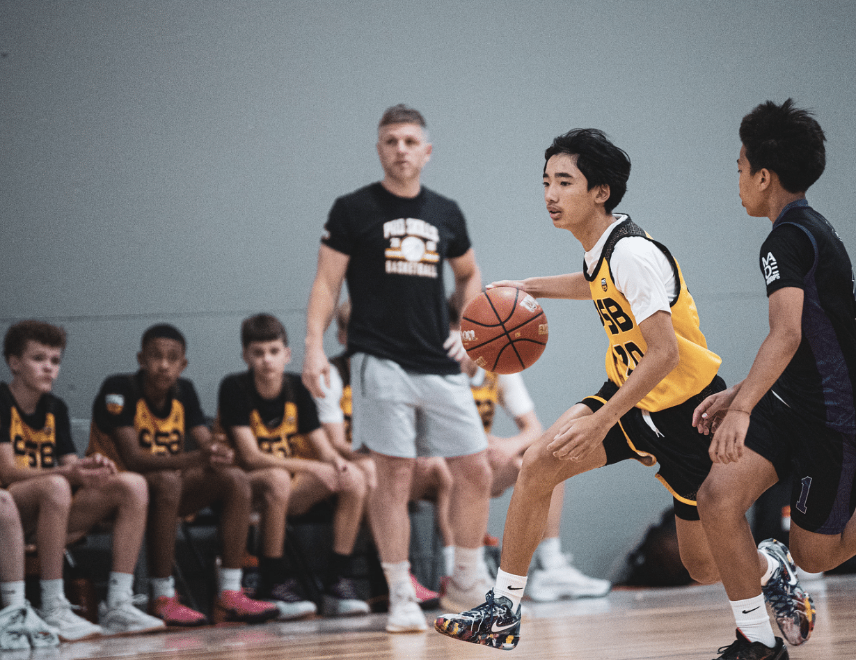 Youth basketball player driving to the basket in a PSB yellow jersey during tournament game