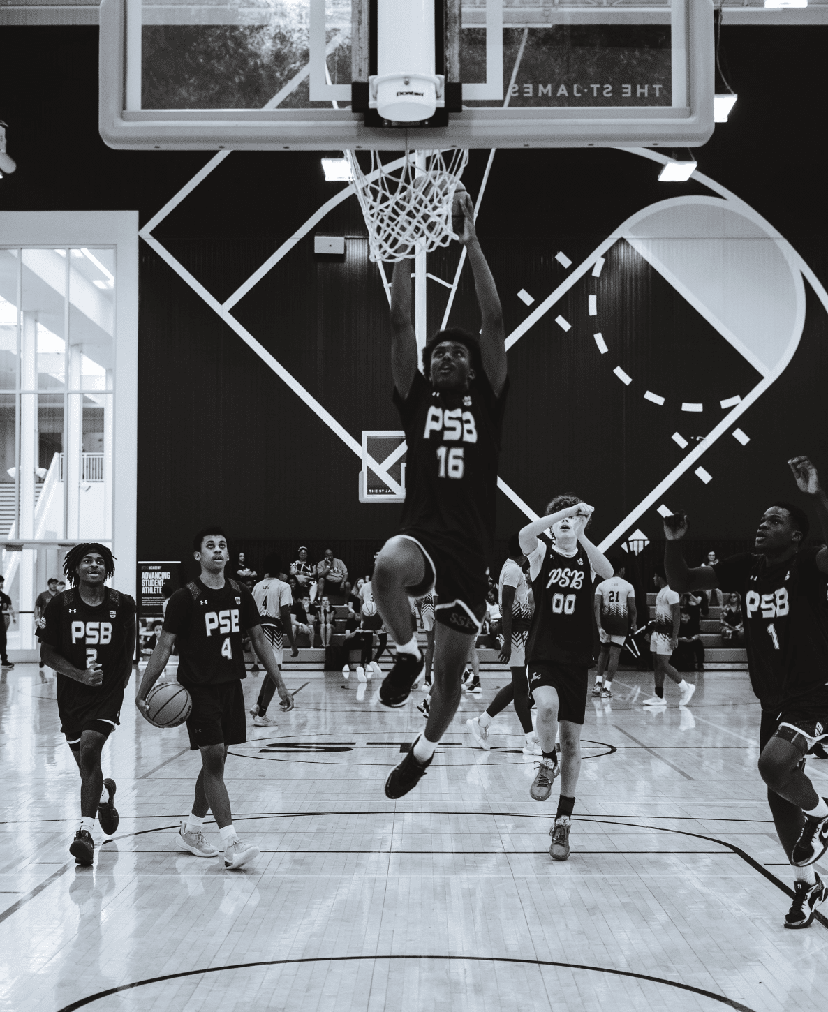 Youth basketball player driving to the basket for a layup, PSB player in dark jersey, black and white action shot