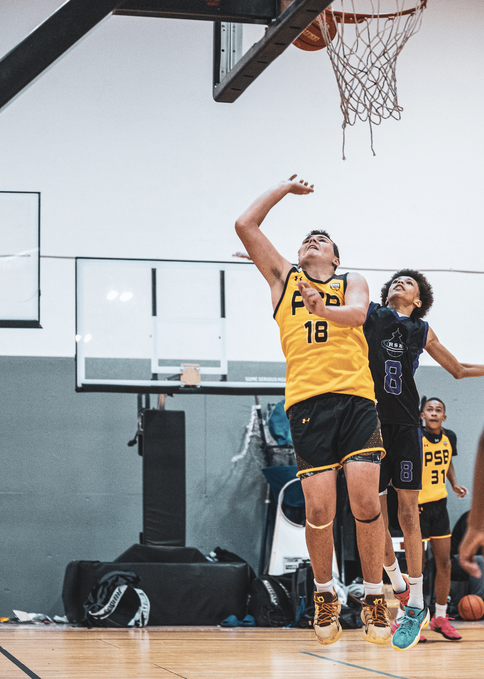 PSB player driving to the basket for a layup during AAU tournament demonstrating explosive power from basketball strength training