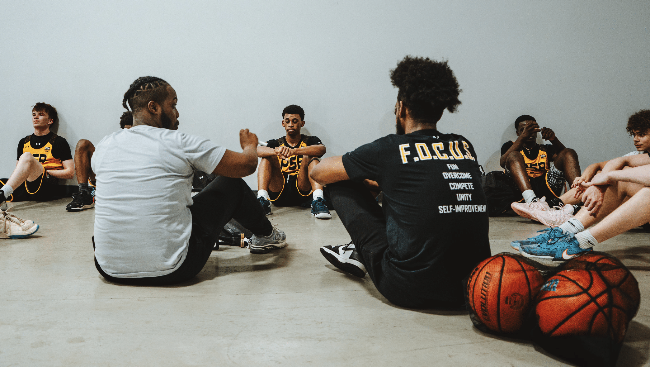 Youth basketball coach talking to players during AAU practice