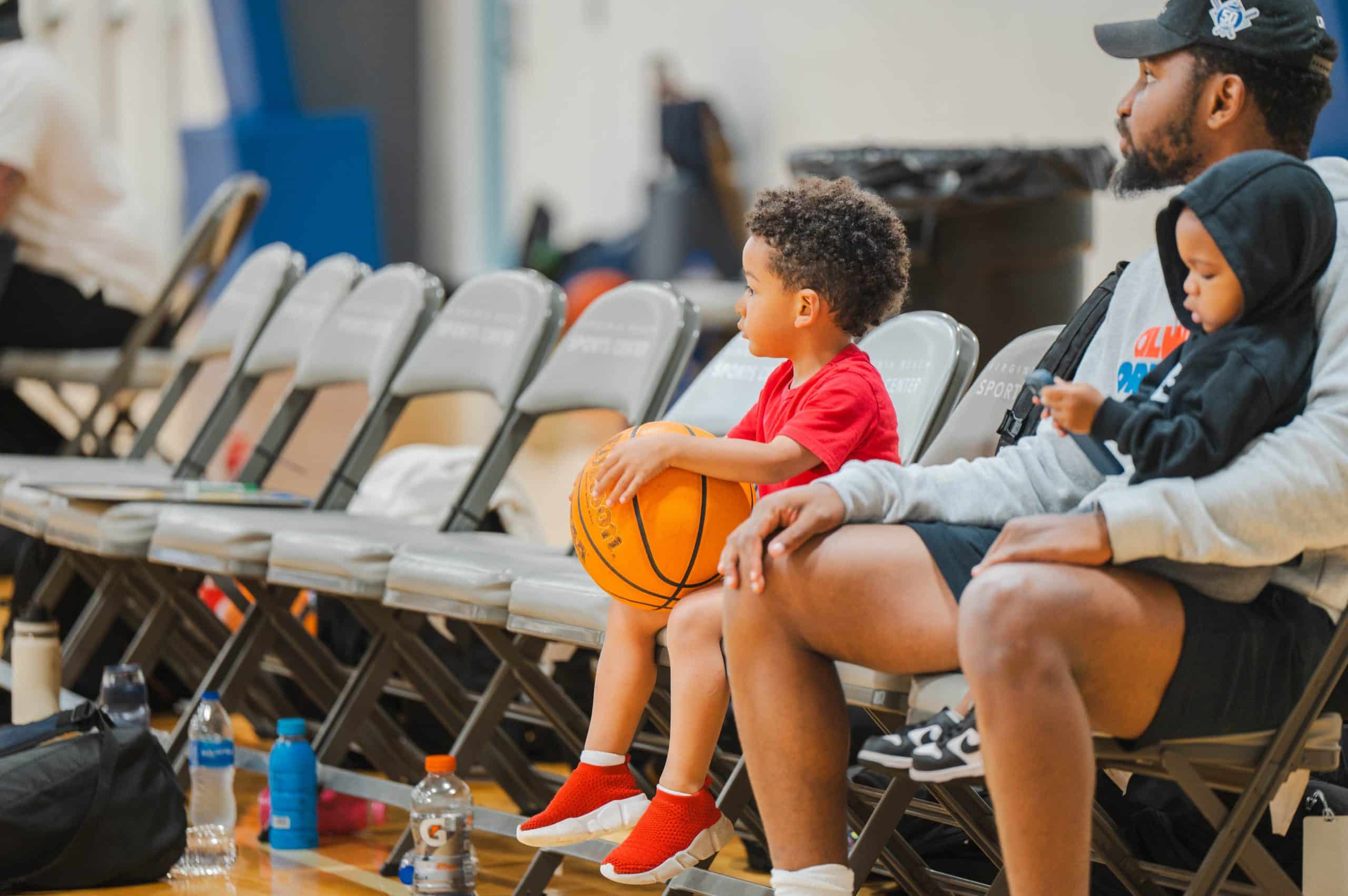 Youth basketball players sitting courtside at a tournament ready to compete
