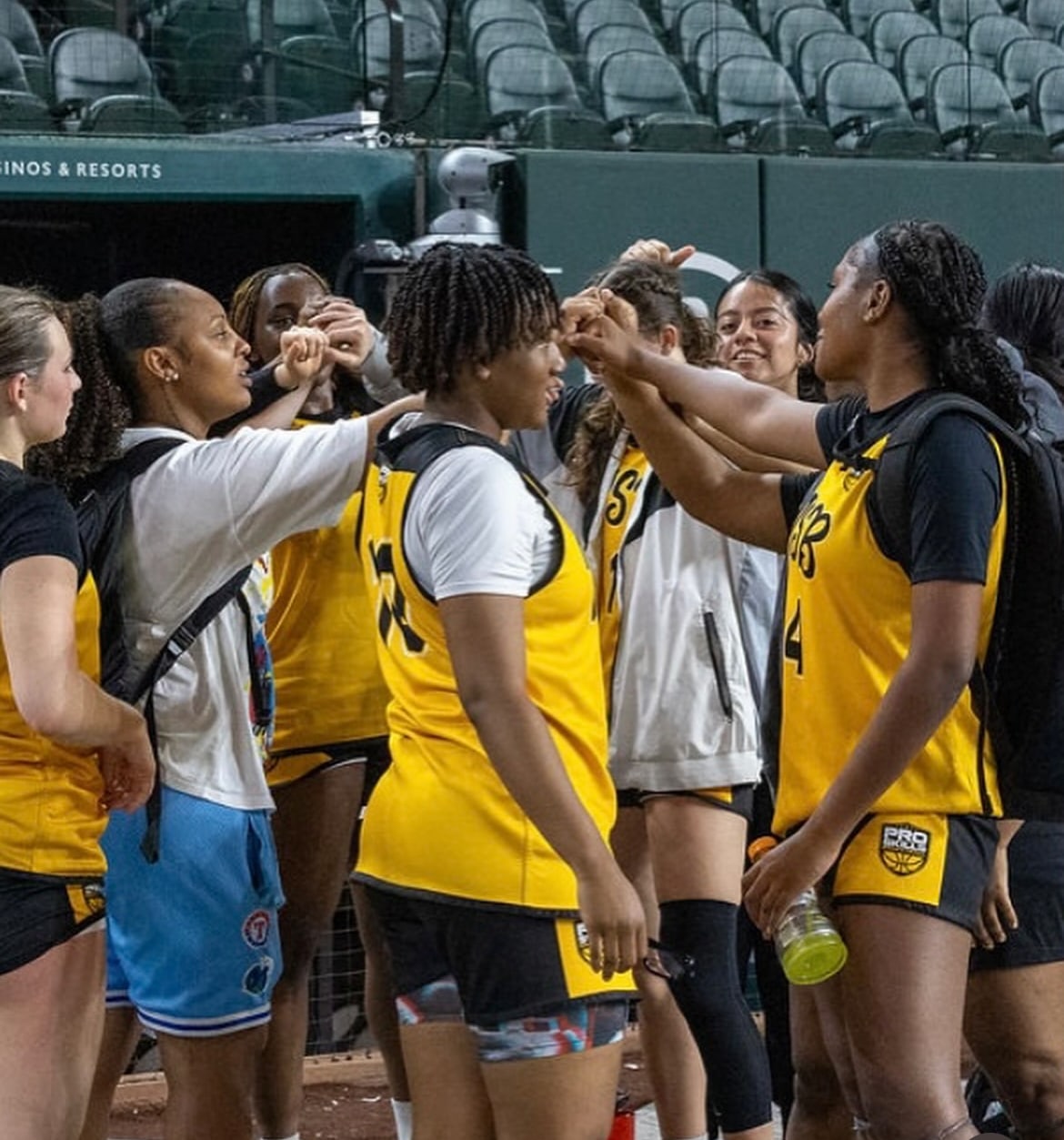 Girls basketball team putting their hands in before a game