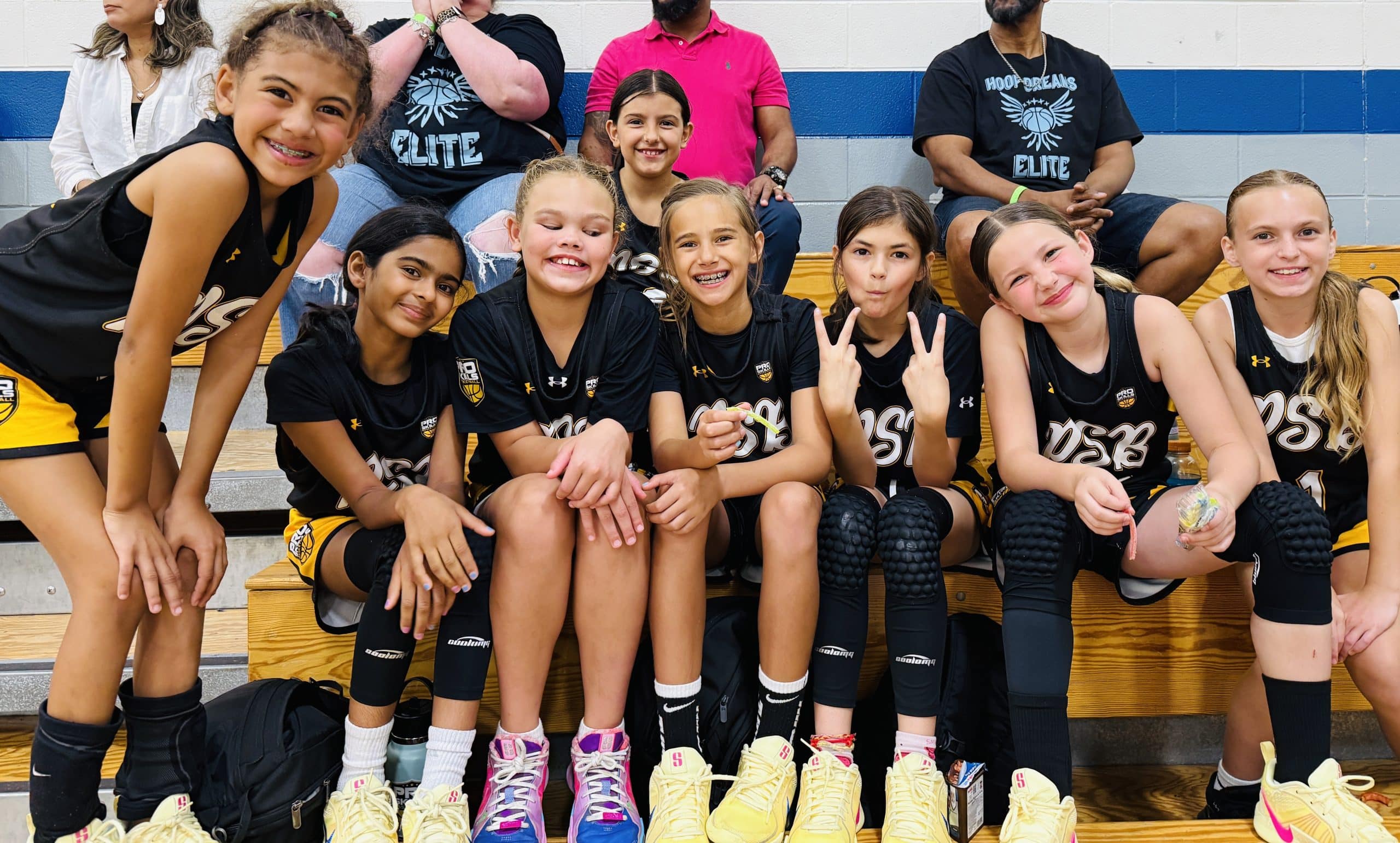 Young girls basketball team posing on the bleachers