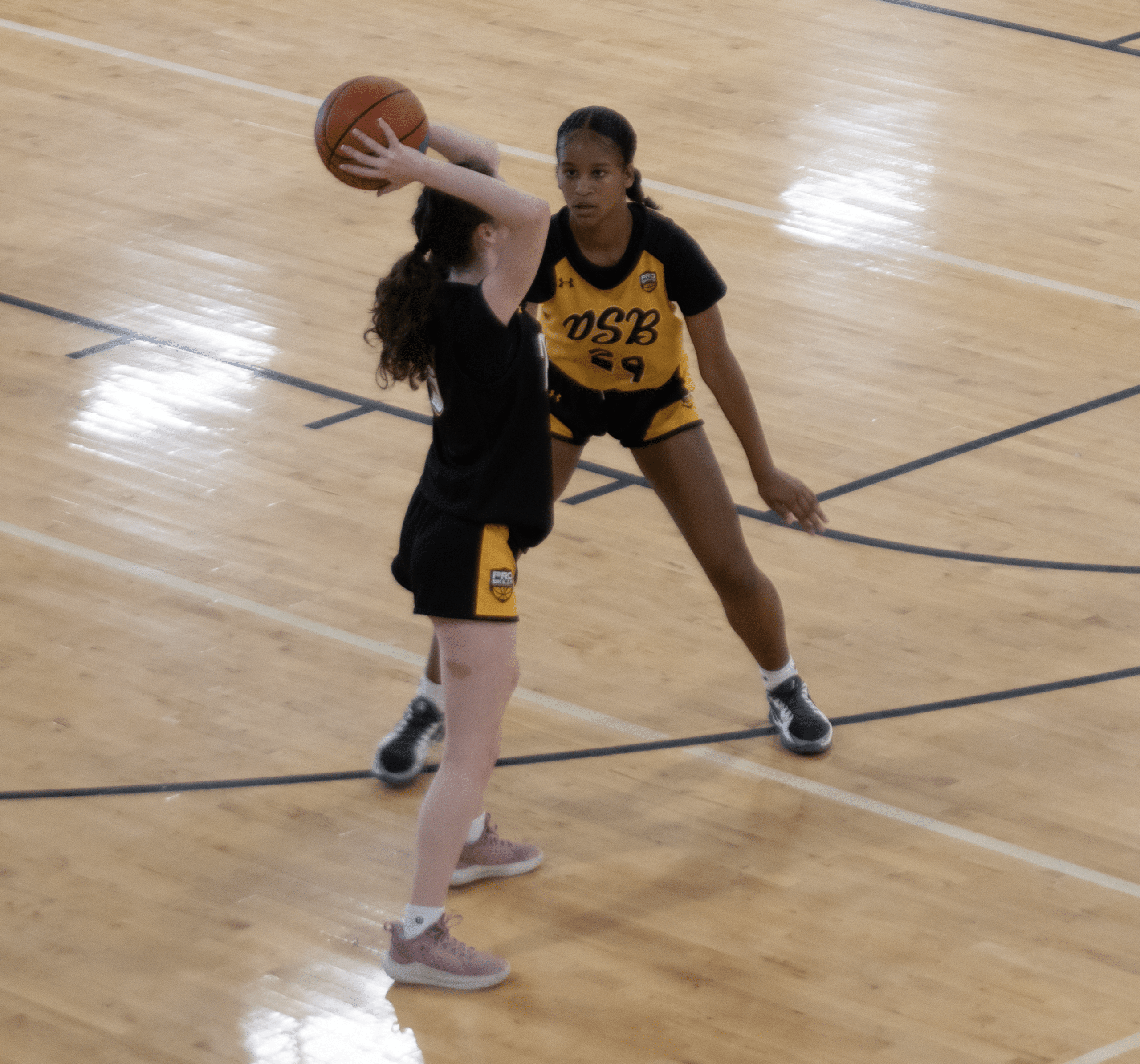 Young player guarding in a low defensive stance