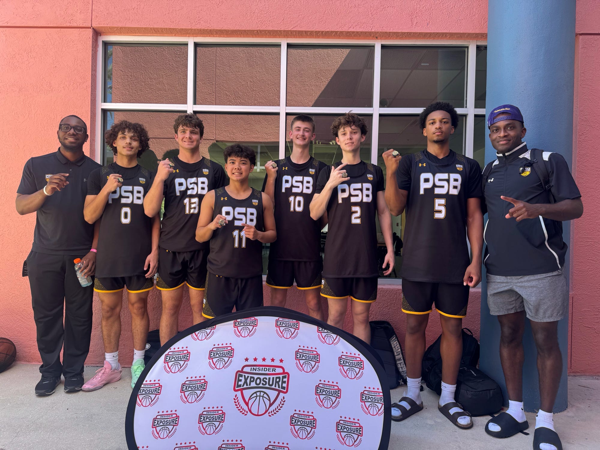 A high school club basketball team and coaches at an out-of-town tournament