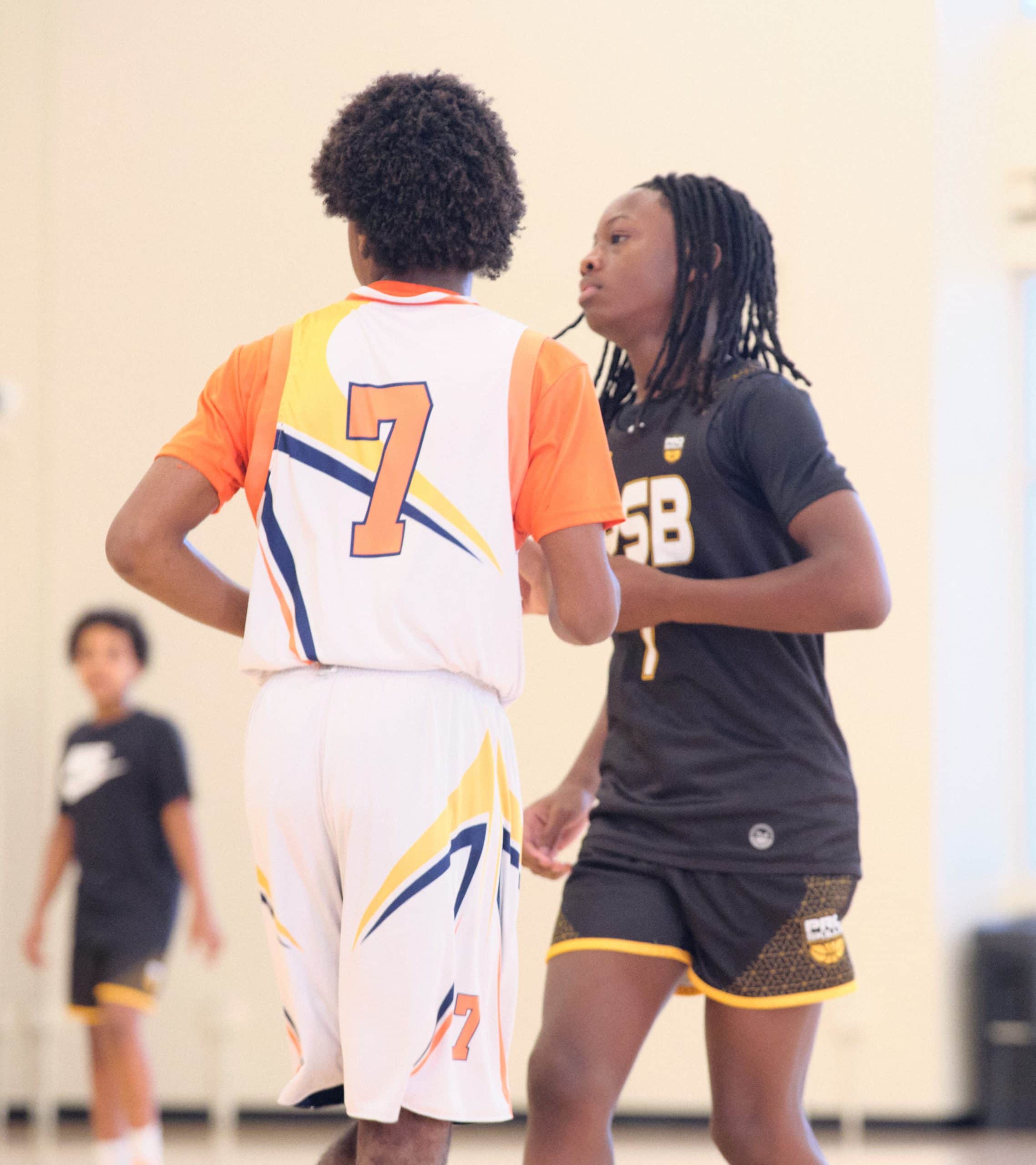 Youth basketball player in a defensive stance guarding an opponent