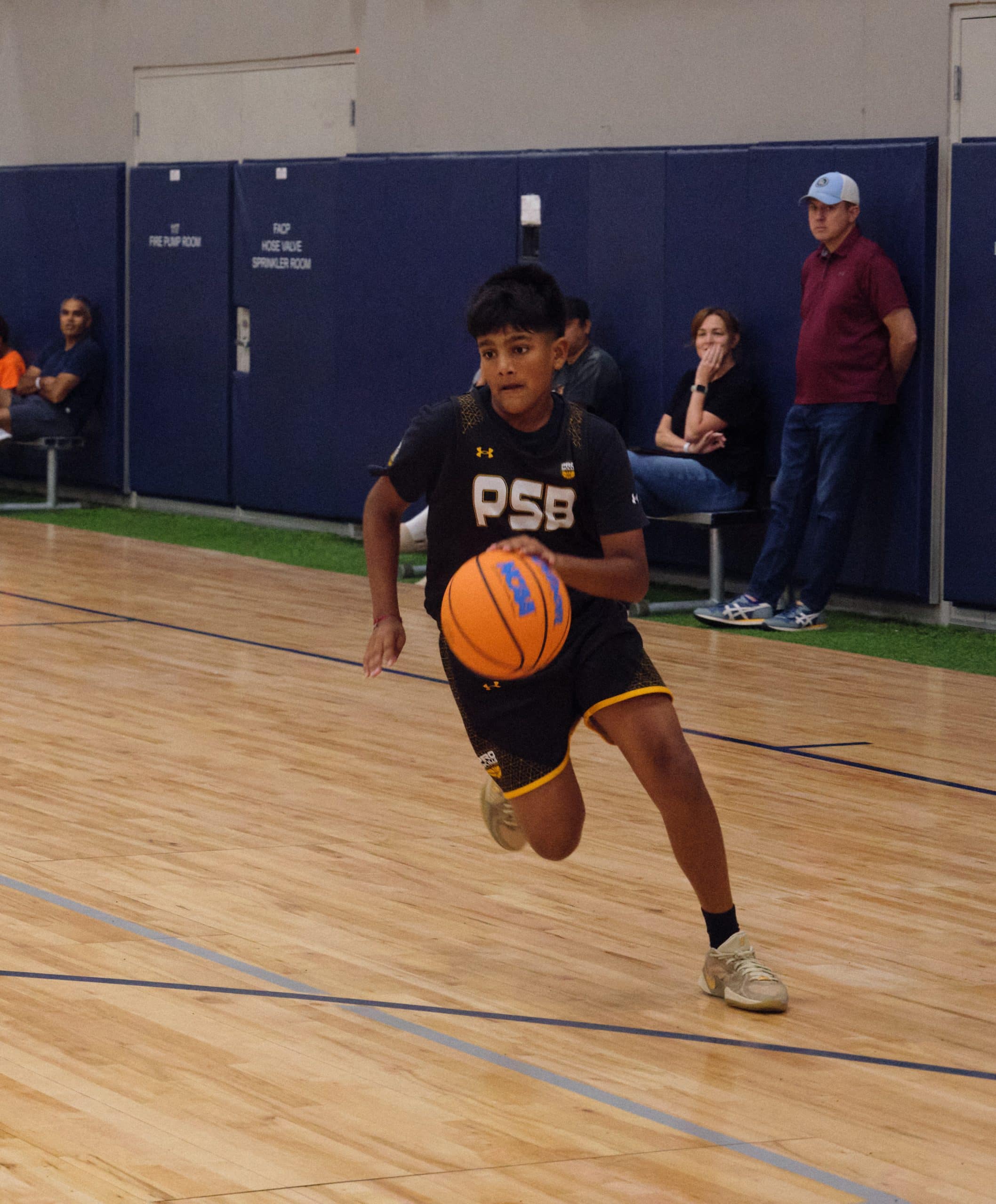 High school basketball player bringing the ball up the court