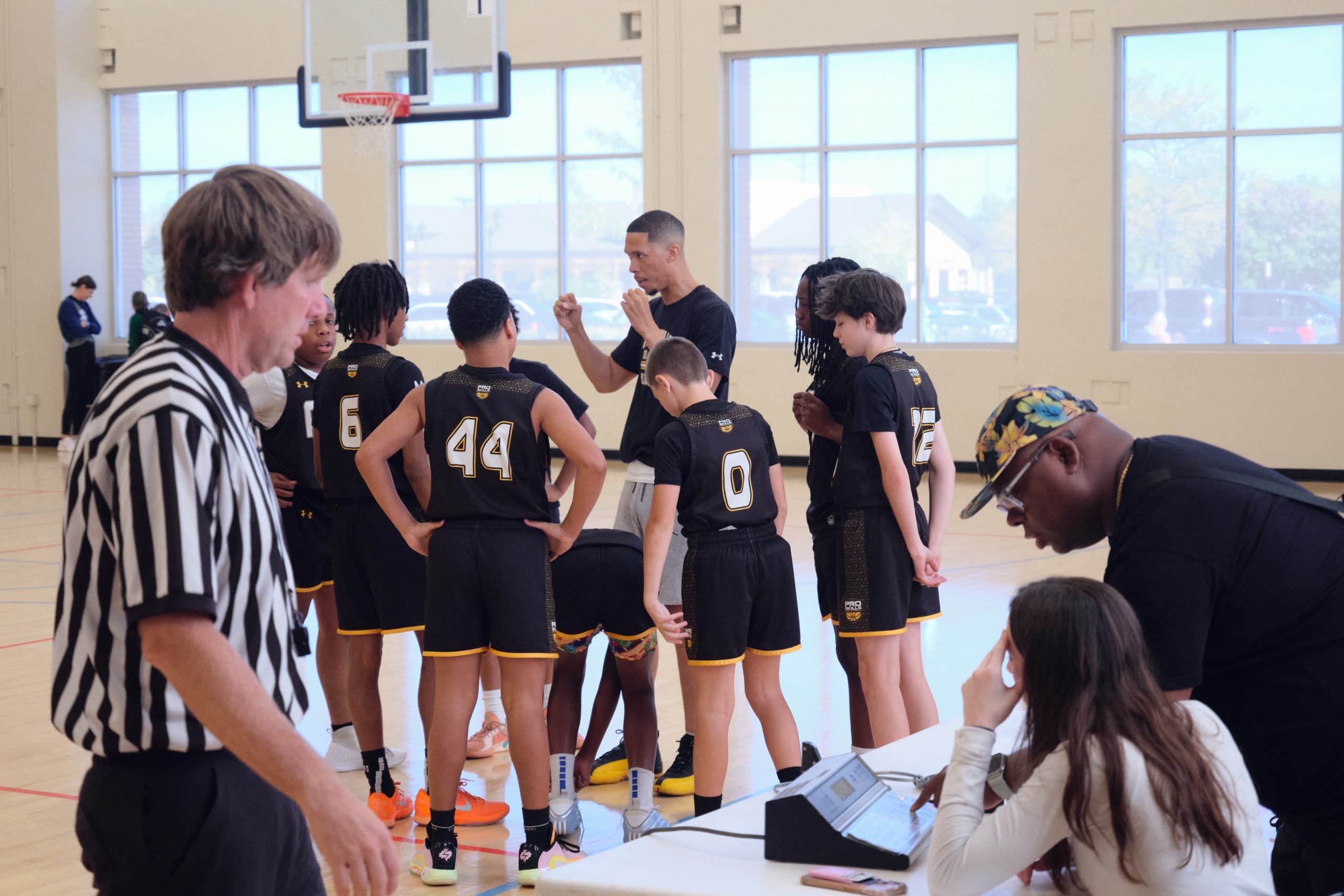 Youth basketball team huddle with their coach