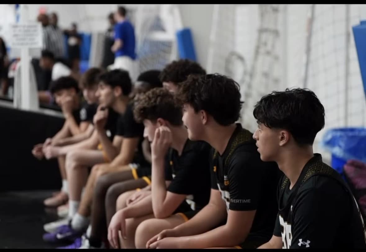 Youth basketball players watching from the team bench