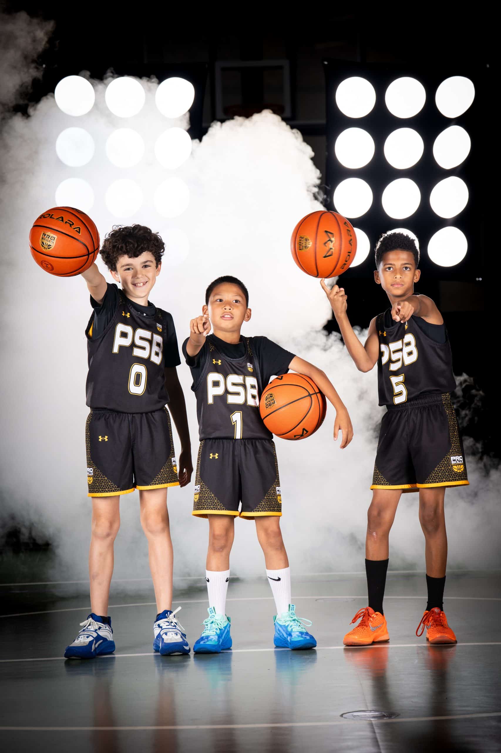 Young basketball players holding the ball together at practice