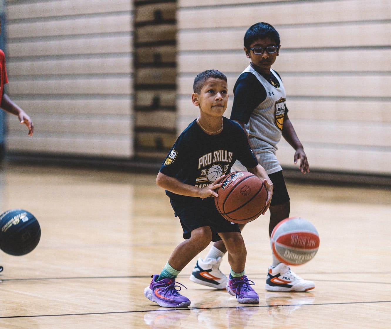 Youth basketball player dribbling past a defender at a skills session