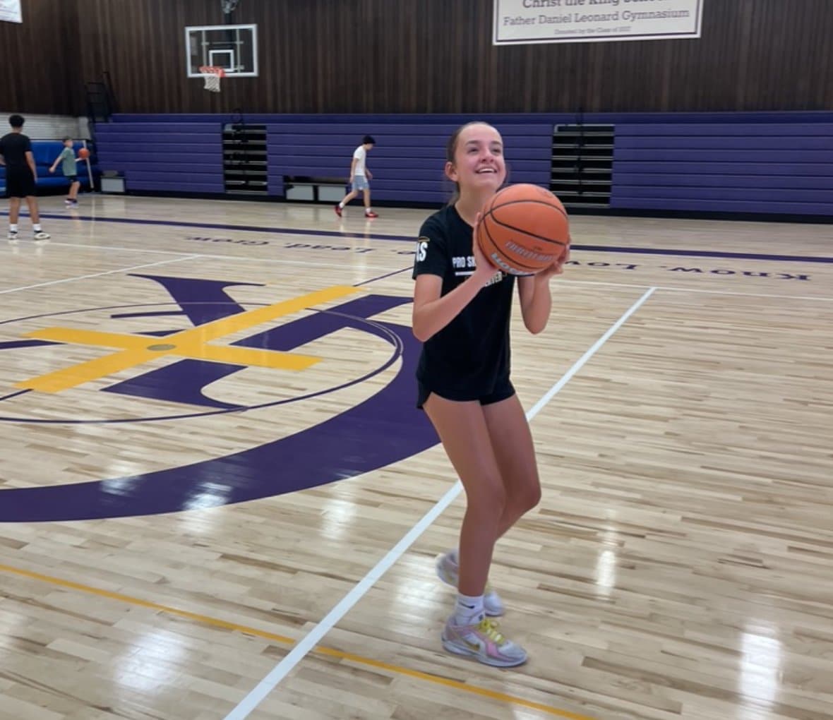 Smiling youth basketball player holding a ball at a PSB clinic