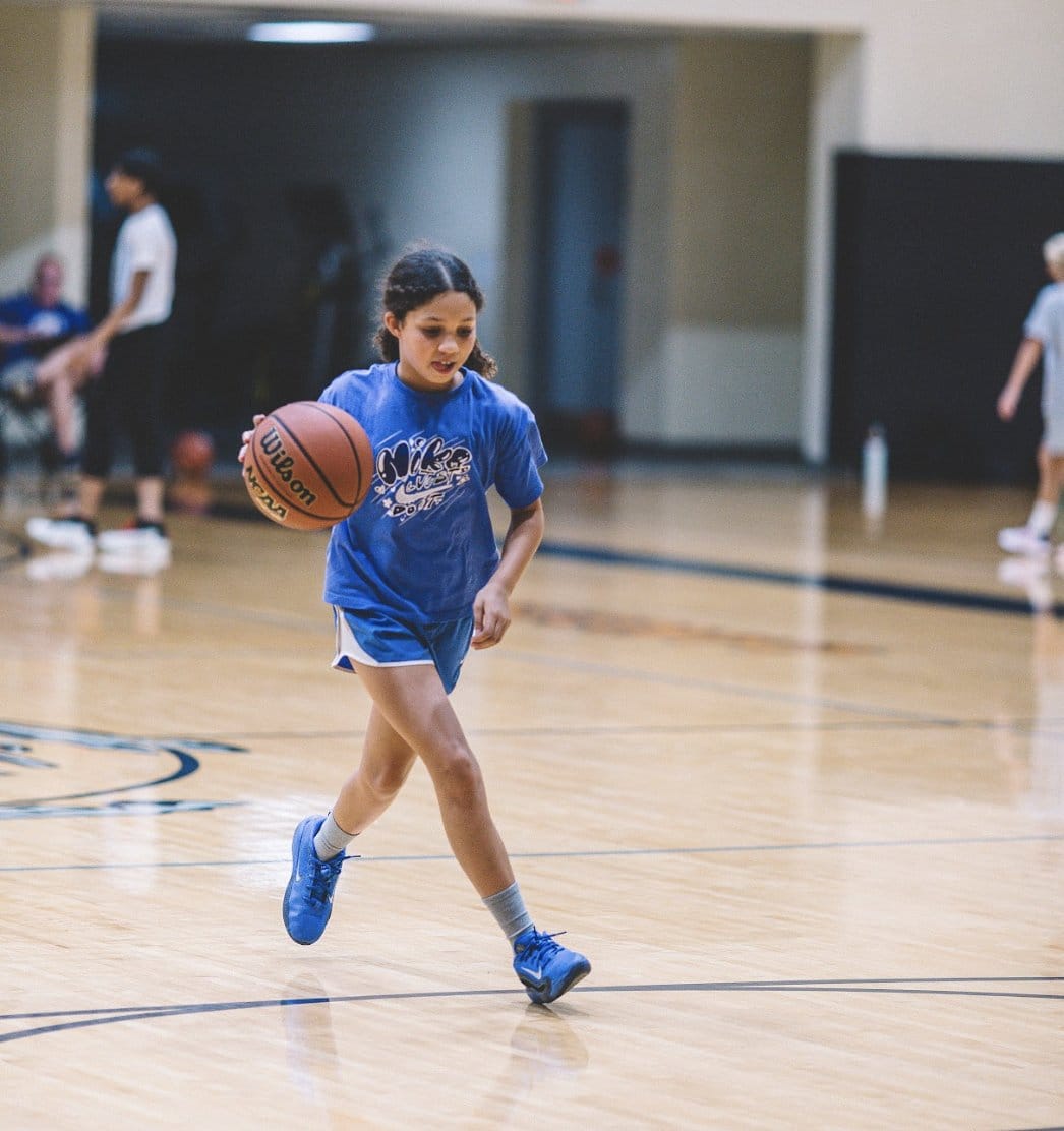 Youth basketball player working on a dribbling drill on an open court
