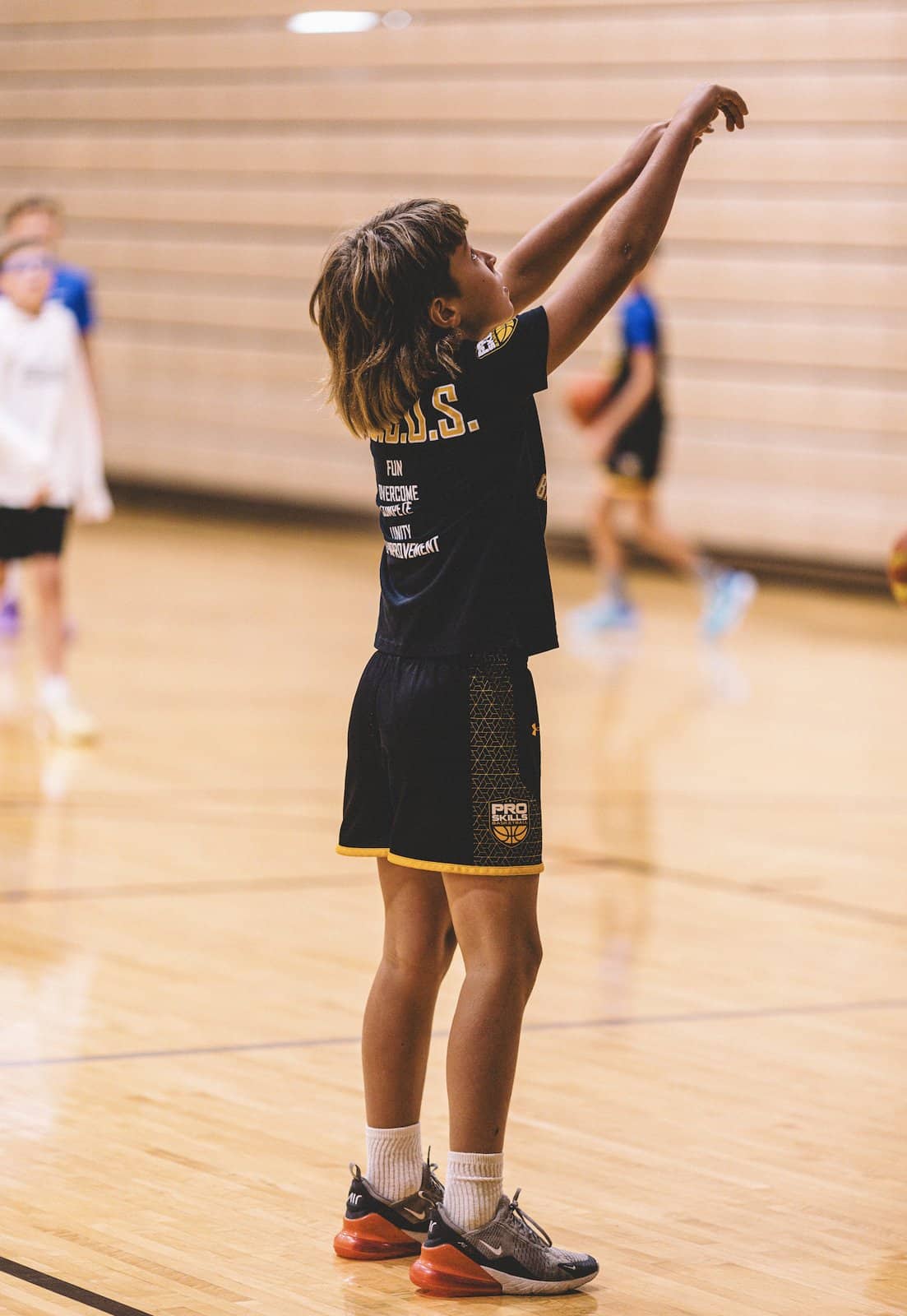 Youth basketball player holding his follow-through after a shot